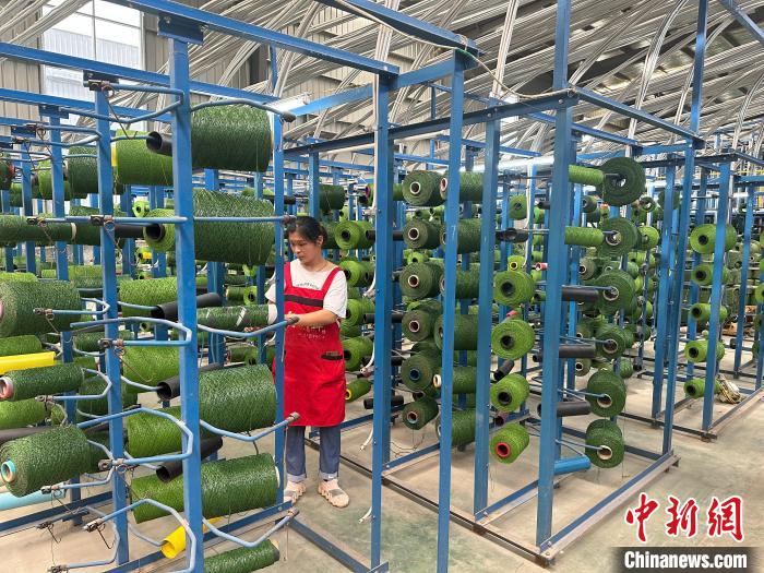 图为山东美森人造草坪有限公司生产车间工人正在加紧赶制海外订单。　闫晓娜 摄