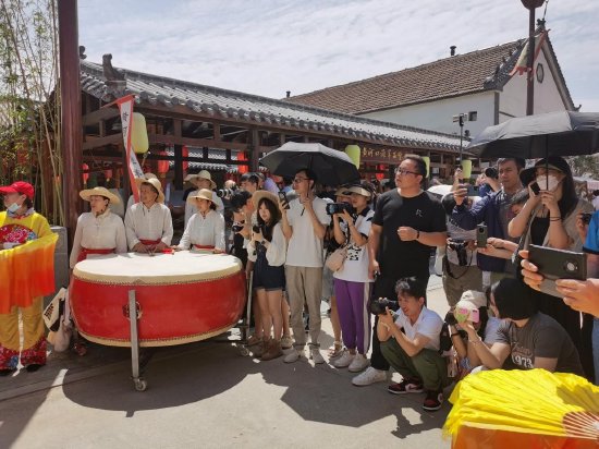 图：众人被老街长巷表演所吸引
