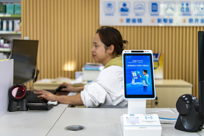 2024年4月10日,浙江金华市区一家民众大药房柜台上设置着医保“刷脸支付”机器,群众看病更加便利。